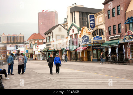 Touristen auf der Promenade in Atlantic City, New Jersey mit Geschäften und Casinos im Hintergrund. Stockfoto