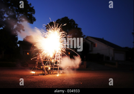 4. Juli Feuerwerk in einer Nachbarschaft. Feuerwerk auf einem Brett zwischen zwei Leitern. Stockfoto