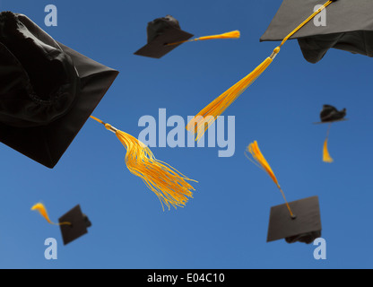 Schwarze Graduierung Hut werfen in die Luft mit gelben Quasten Stockfoto