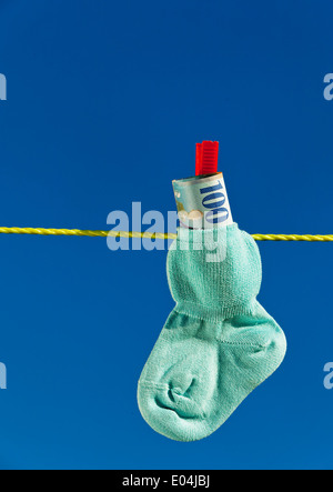 Baby Socken auf der Wäscheleine mit Schweizer Franken. Blauer Himmel., Baby Socken Auf Waescheleine Mit Schweizer Franken. Blauer Himmel. Stockfoto