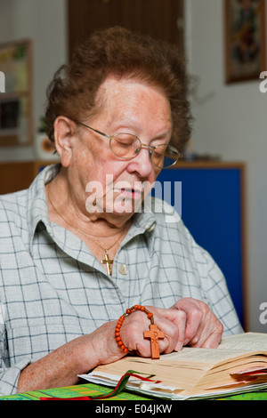 Alte Frau in der Bibel liest und betet, Alte Frau liest in der Bibel Und Kurzfilms Stockfoto