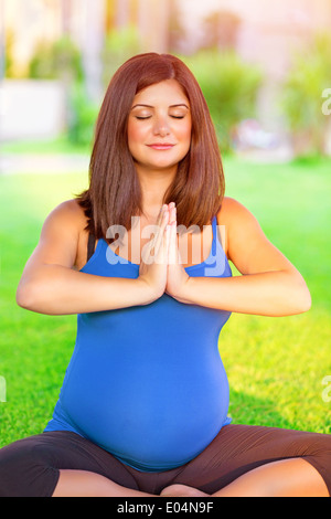 Porträt von schöne schwangere Frau mit geschlossenen Augen in Yoga im Freien, Sport für gesunde Schwangerschaft beschäftigt Stockfoto