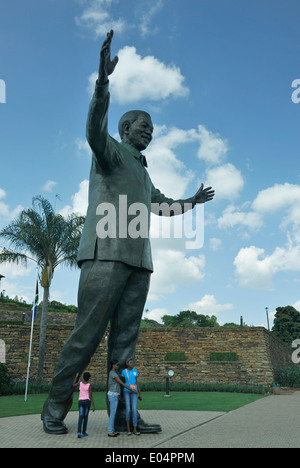 Tswane, Pretoria, Gauteng, Südafrika, drei Mädchen neben Bronzestatue von Nelson Mandela im Garten der Union Buildings Stockfoto