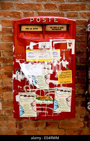 Feld für italienische Zeichen in rot Pasten mit ganz vielen Broschüren, Italienischer Postkasten in Rot Beklebt Mit Ganz Vielen Werbezette Stockfoto