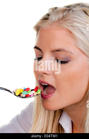 Junge Frau mit vielen Tabletten auf Löffel:, Junge Frau Mit Vielen Tabletten Auf Löffel: Stockfoto