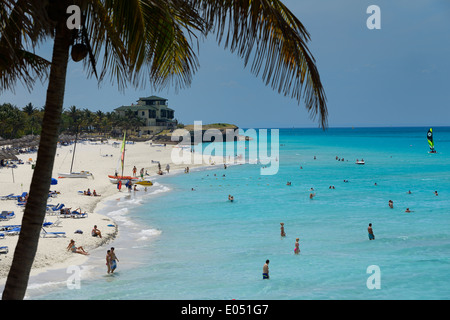 Kokospalme und Xanadu Herrenhaus im White sand Strand von Varadero Resort Kuba mit Touristen im türkisfarbenen Wasser des Atlantischen Ozeans Stockfoto