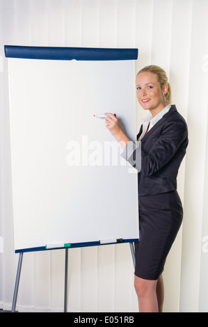 Eine junge Frau mit einem Flipchart-Board mit einer Präsentation. Weiter Bildung und Erwachsenenbildung Ausbildung., Eine Junge Frau Mit Einer Fli Stockfoto