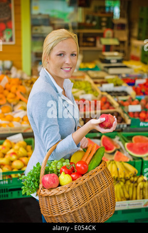 Eine junge Frau kauft Obst und Gemüse auf einem Wochenmarkt. Frische und gesunde Lebensmittel., Eine Junge Frau Kauft Obst Und Gemüse Auf e Stockfoto