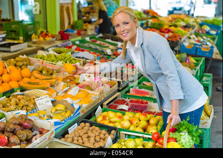 Eine junge Frau kauft Obst und Gemüse auf einem Wochenmarkt. Frische und gesunde Lebensmittel., Eine Junge Frau Kauft Obst Und Gemüse Auf e Stockfoto