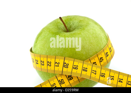 Ein Apfel mit Dimension Klebeband. Symbol für Ernährung mit Obst, Ein Apfel Mit Massband. Symbol Fuer Diaet Mit Obst. Stockfoto