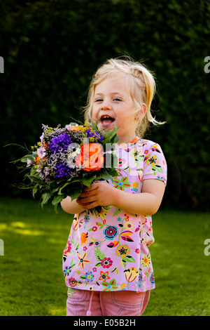 Kleines Kind mit Bouquet. Geschenk zum Muttertag, kleine Art Mit Blumenstrauss. Meistverkauftes Fuer Muttertag Stockfoto