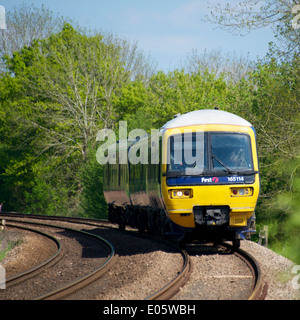 Brockham, Dorking, Surrey. Samstag, 3. Mai 2014. Erster große 165114 Westbahn Zug nähert sich einem Bahnübergang Stockfoto