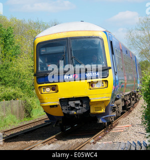 Brockham, Dorking, Surrey. Samstag, 3. Mai 2014. Erster große 165114 Westbahn Zug nähert sich einem Bahnübergang Stockfoto