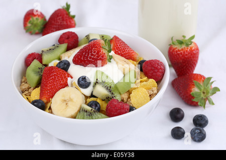 Früchte-Müsli mit Joghurt, Erdbeeren, Bananen, Himbeeren, Kiwi und Blaubeeren zum Frühstück Stockfoto