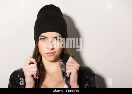 Niedliche Hipster Teenager-Mädchen mit schwarze Mütze Hut posiert, Blick in die Kamera gegen die weiße Wand Stockfoto