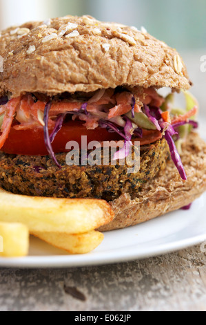 Vegane schwarze Bohne Fiesta Burger mit Koriander Jimca Fiesta Krautsalat und Pommes-Frites. Stockfoto