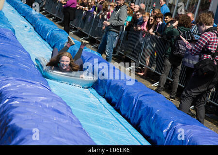 Bristol, UK. 4. Mai 2014. Lächelnde Frau Folien Parkstraße Wasser rutschen Credit: Rob Hawkins/Alamy Live News Stockfoto