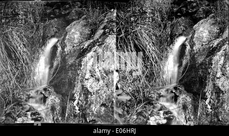 Dieses Bild zeigt einen kleinen Wasserfall, wahrscheinlich in einem ländlichen oder gebirgigen Gebiet. Es unterstreicht die natürliche Schönheit und Ruhe des fließenden Wassers in seiner ruhigen Umgebung. Stockfoto
