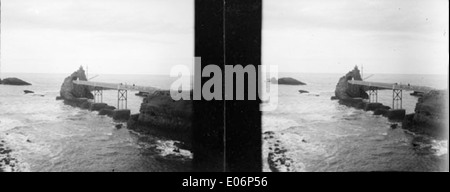 Eine stereoskopische Fotografie aus dem Jahr 1908 vom Felsen der Jungfrau (Rocher de la Vierge) in Biarritz, Frankreich. Das Bild zeigt die berühmte Felsformation an der Küste, die in Schwarz-weiß erfasst wurde und die natürliche Schönheit und die historische Bedeutung der Landschaft von Biarritz unterstreicht. Stockfoto