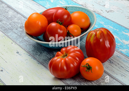 Verschiedene Tomaten in einer Schüssel auf Holztisch Stockfoto