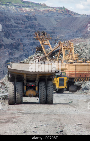 Eisen Sie Erz Tagebau - schwere Muldenkipper in der Schlange für die Beladung Stockfoto