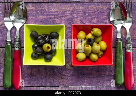 Bunte Obst Oliven in Schalen auf Holztisch Stockfoto