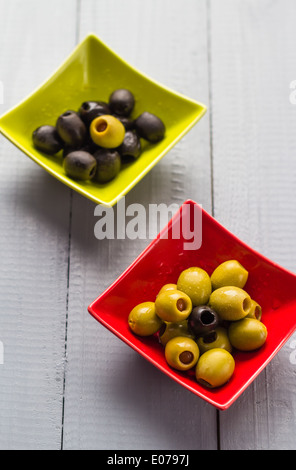 Bunte Obst Oliven in Schalen auf Holztisch Stockfoto