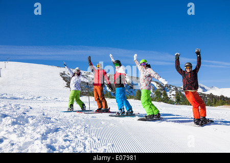 Skifahrer und Snowboarder in Folge Hände anheben Stockfoto