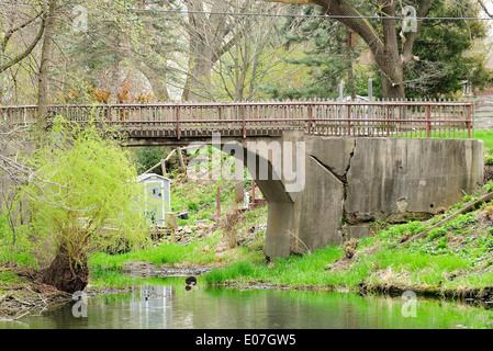 Zerfallende Brücke über den Kanal zur Insel führt. Stockfoto