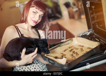 Junge Frau backen Kekse für ihren Hund Stockfoto