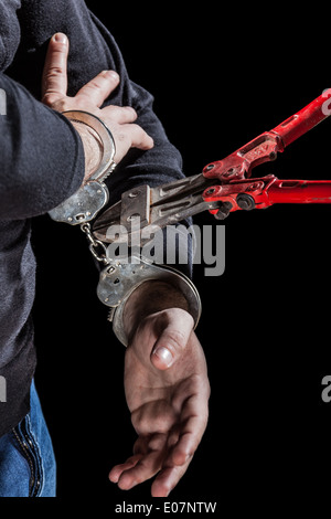 Kriminelle, die versuchen, Handschellen mit einer großen Schere zu brechen Stockfoto