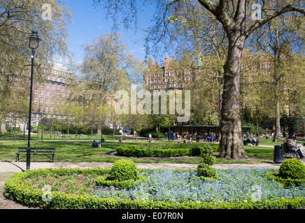 Russell Square im Frühjahr mit Menschen sitzen, Wandern, relaxen mit Blumen im Vordergrund Bloomsbury London England UK Stockfoto