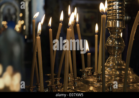 Mehrere große Kerzen in einem dunklen Raum in der Kirche Stockfoto