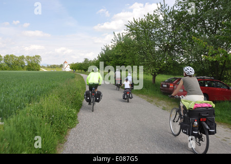 Ein Radfahrer vorbei an eine Familie von Radfahrern auf einem Radweg entlang der Eurovelo 6 am Stadtrand von Deggendorf, Bayern, Deutschland. Stockfoto