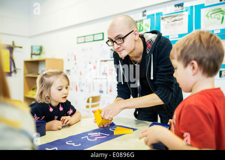 Männliche Lehrer, die Schüler im Kunstunterricht im Kindergarten zu unterstützen Stockfoto