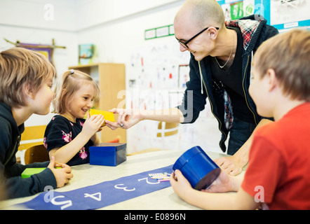 Glückliche Lehrer Unterstützung Schüler im Kunstunterricht im kindergarten Stockfoto