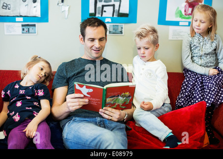 Männliche Lehrer Geschichte Buch für Kinder im kindergarten Stockfoto