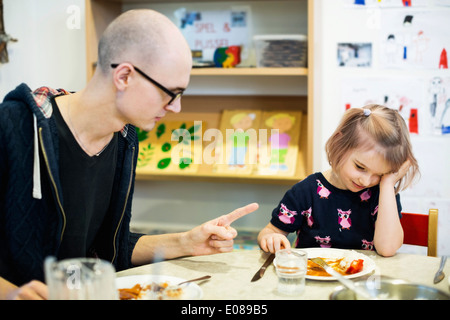 Männliche Lehrer Schelte Mädchen für nicht mit Essen im kindergarten Stockfoto