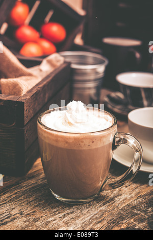 Heißer Kakao mit Schlagsahne in klaren Gläsern Becher trinken. Stockfoto