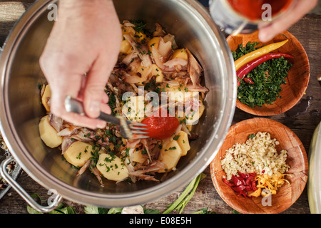 Person vorbereiten Kartoffelsalat Stockfoto