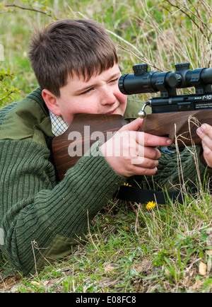 Ein kleiner Junge mit einem Luftgewehrschießen Stockfoto