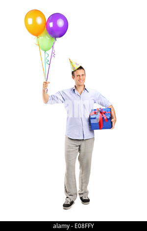 In voller Länge Portrait eines Mannes mit Partyhut mit Luftballons und ein Geschenk Stockfoto