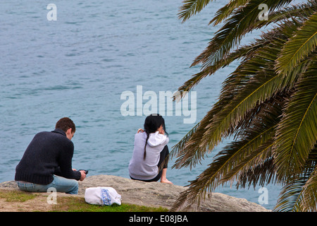 Junge Frau und Mann sitzt am Hafen, Watsons Bay, Sydney. Stockfoto