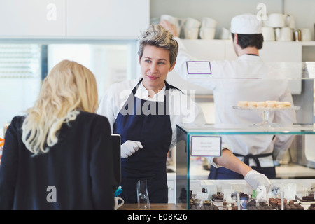 Weibliche Café Arbeitnehmer behandelnden Kunden am Schalter Stockfoto