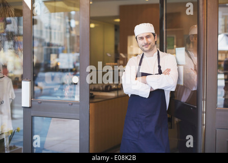 Porträt von zuversichtlich Besitzer stehen mit verschränkten am Café Eingang Stockfoto