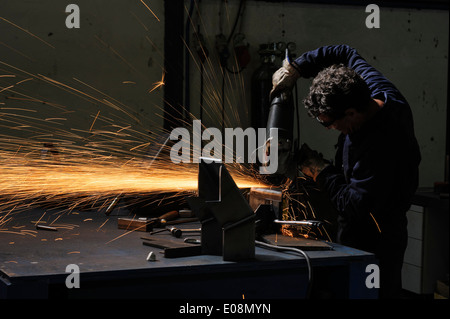 Fabrikarbeiter, die mit Winkelschleifer Metall schneiden Stockfoto