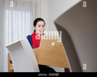 Junge Frau mit einem Apple MacBook Laptop-Computer zu Hause Stockfoto