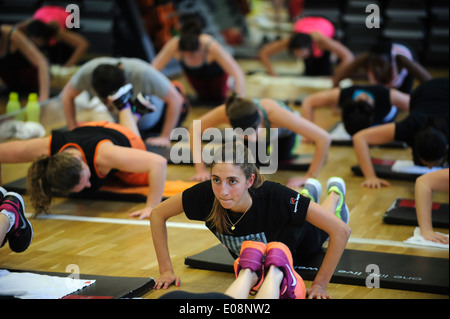 Junge Frau tut Push Ups während einer Body Pump-Fitness-Klasse in der Turnhalle Stockfoto