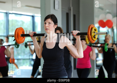 Junge Frau während einer Body Pump-Fitness-Klasse in der Turnhalle Stockfoto