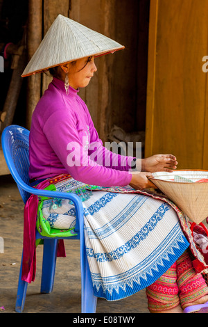 Eine junge Frau aus der Flower Hmong Bergstämme verkaufen Hüte auf dem ethnischen Wochenmarkt In Coc Li, Provinz Lao Cai, Vietnam Stockfoto